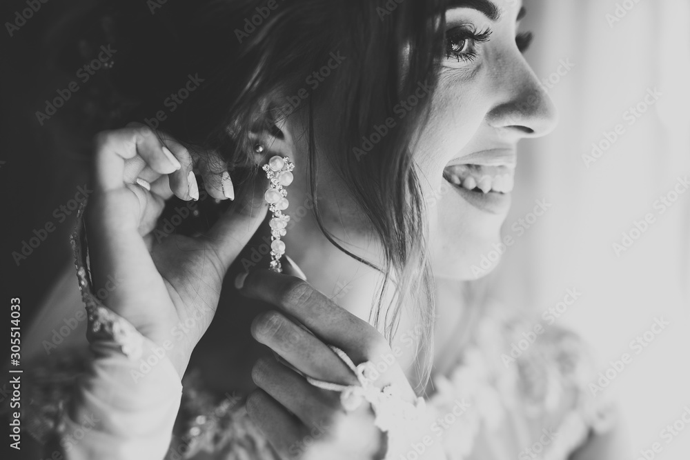 Obraz premium Beautiful bride wearing fashion wedding dress with feathers with luxury delight make-up and hairstyle, studio indoor photo shoot