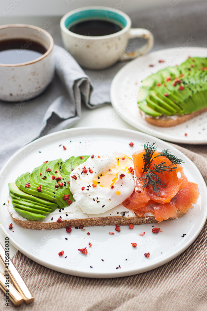Toast with cream fresh, smoked salmon, poached egg and sliced avocado, and two cups of coffee. Toast with cream fresh, smoked salmon, poached egg and sliced avocado, and two cups of coffee.
