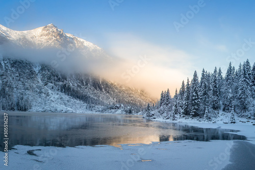 Fototapeta Naklejka Na Ścianę i Meble -  Winter mountains at sunrise. Amazing snowy nature landscape in sunlight. Scenery mountain clean icy lake in the morning