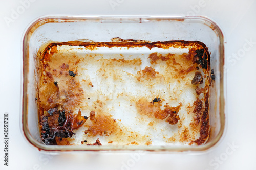 Rectangular glass baking dish top view. Dirty meat baking dish. An empty tray made of heat resistant glass after baking meat.