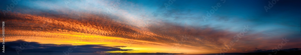 Fototapeta premium Fantastic dark thunderclouds at sunrise, wide panorama