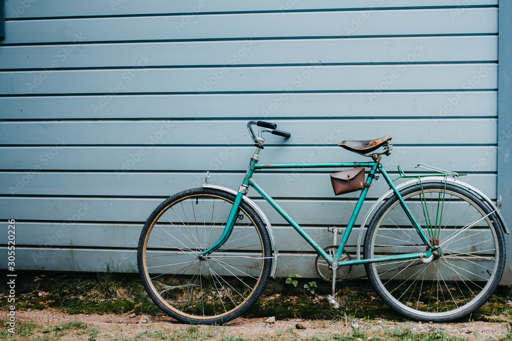 Retro bicycle stands against a blue wall