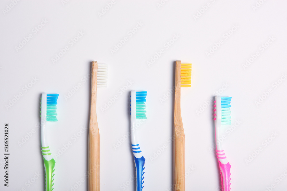 natural bamboo toothbrushes and plastic on a colored background top view. natural bamboo toothbrushes and plastic on a colored background top view.
