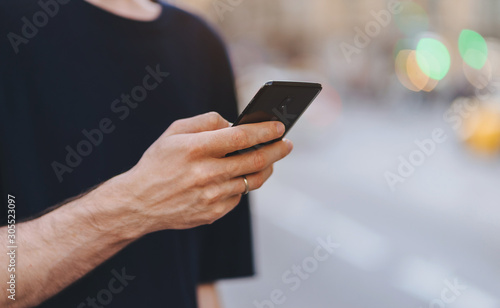 Social media concept, Close-up of male hand holding smartphone outdoor, Businessman typing text message on the street