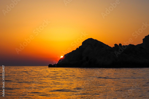 Corfu sunset against the backdrop of a mountain silhouette.