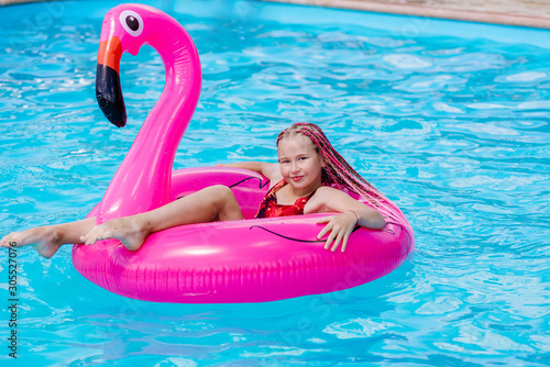 Girl swims on an inflatable flamingo © sushytska