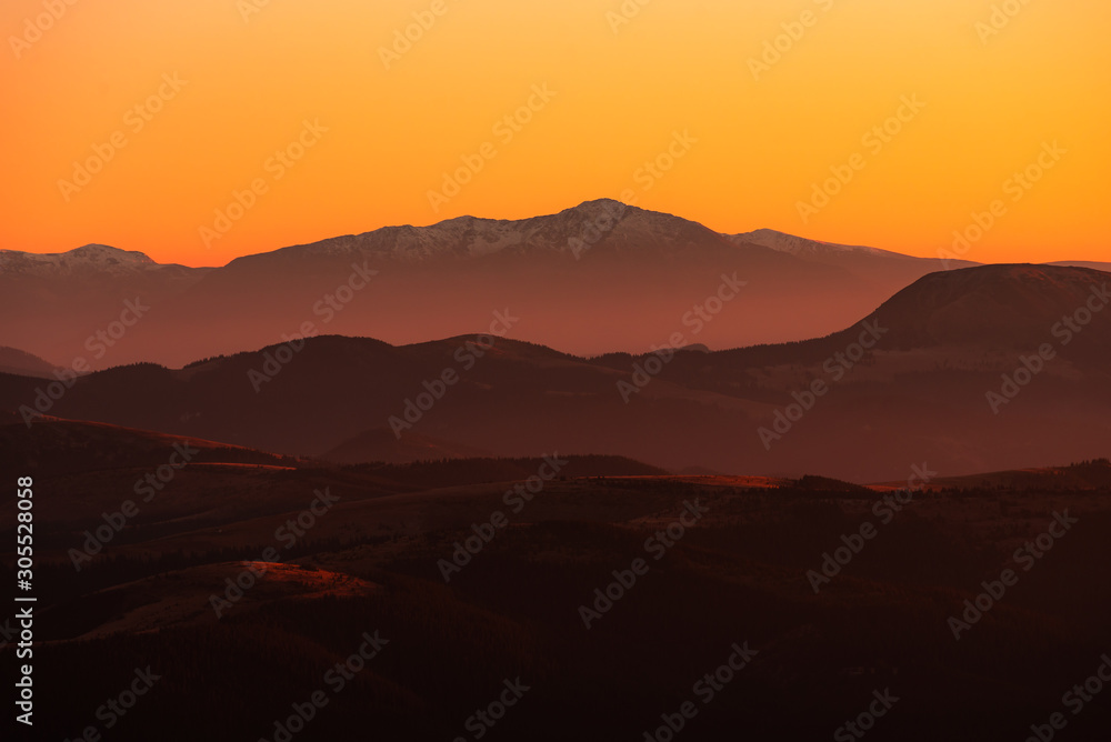 Sunset mountain peaks covered with snow . Carpathians mountain peaks sunset view. Sunset  mountain peaks silhouette.