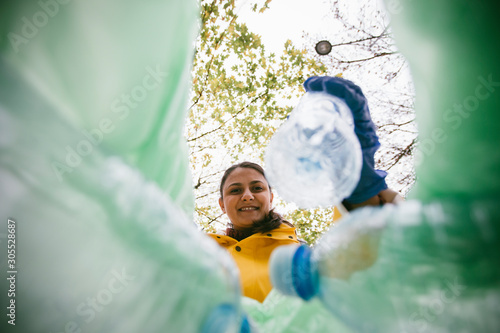 Photography Volunteer with garbage bags collecting plastic bottles
