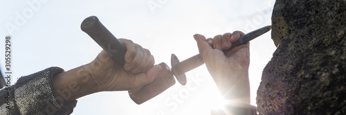 Wall Mural An artist carving in stone using mallet and a chisel
