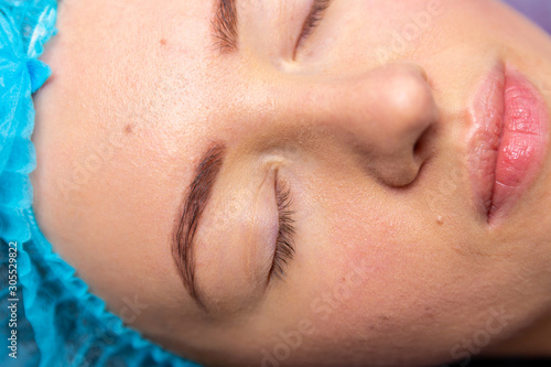 Receiving electric darsonval facial massage procedure at beauty salon