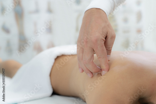 Young woman receiving shoulder massage in a physiotherapy center