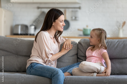 Happy mother and cute child enjoy talking relaxing on sofa © fizkes