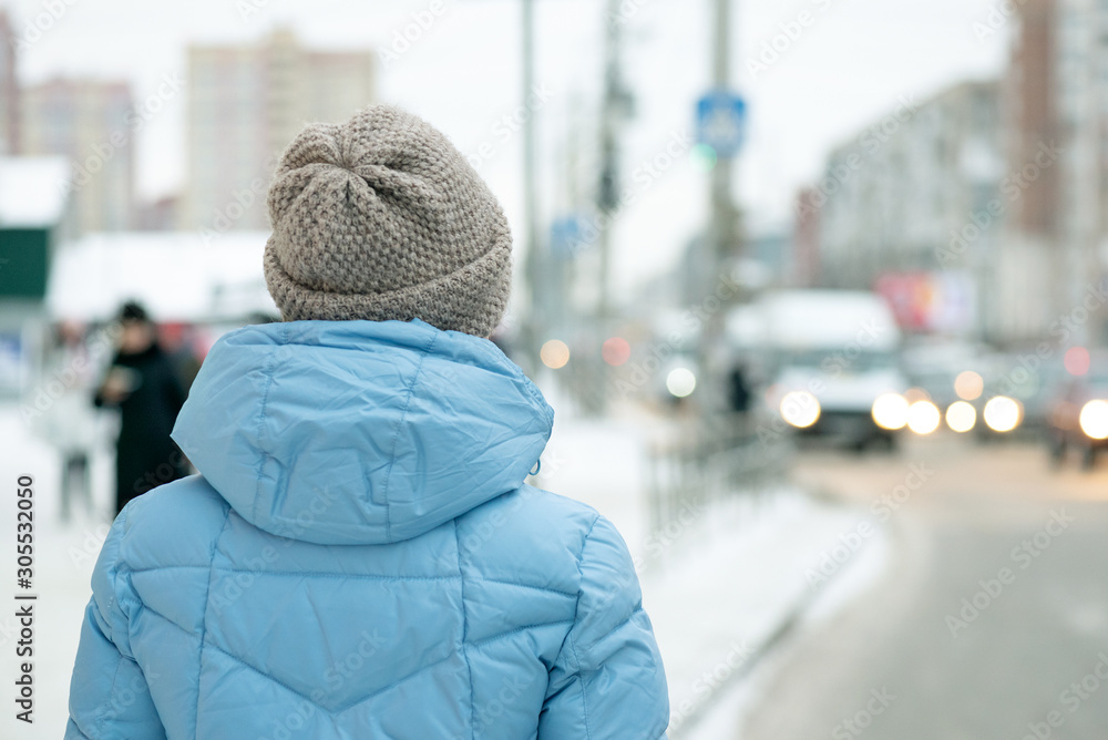 Woman waiting a bus on the bus stop in winter. Woman waiting a bus on the bus stop in winter.