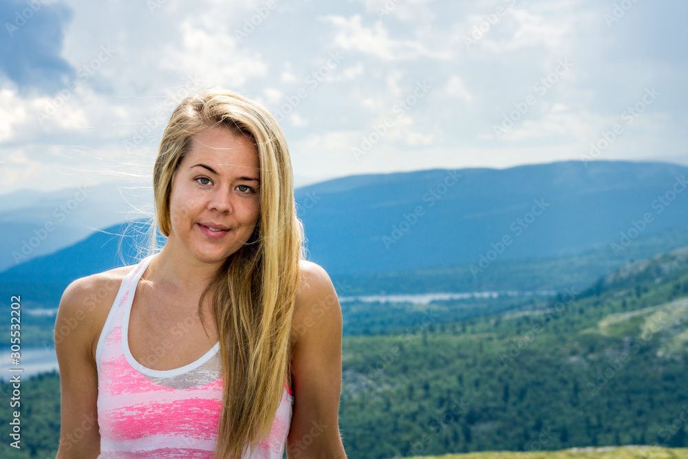Portrait of sporty blonde girl in natural environment in nice weather. Healthy, fitness and nutrition concept. Copy space for text and landscape scenery in the background.