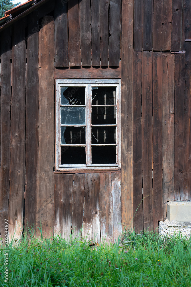 Broken window in an abandoned weathered shed Broken window in an abandoned weathered shed