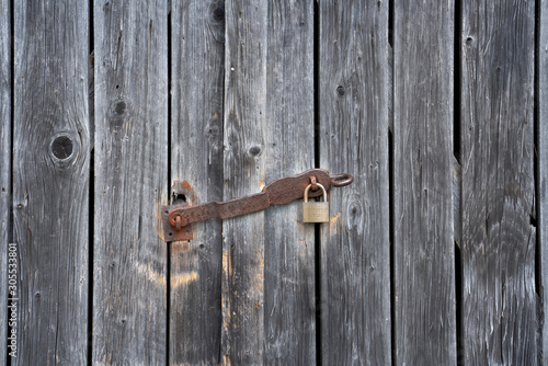 Wooden shelter door with rusty padlock
