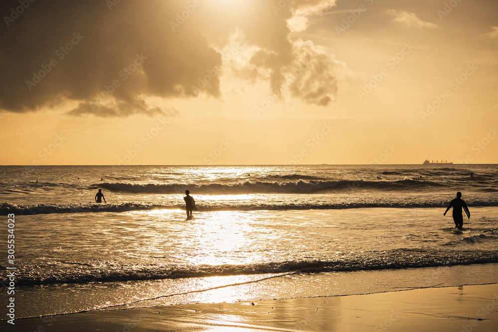 Surfer on the beach at sunset, Caravelos beach, Portugal