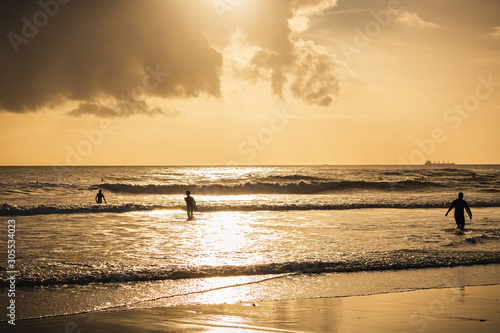 Fototapeta Naklejka Na Ścianę i Meble -  Surfer on the beach at sunset, Caravelos beach, Portugal