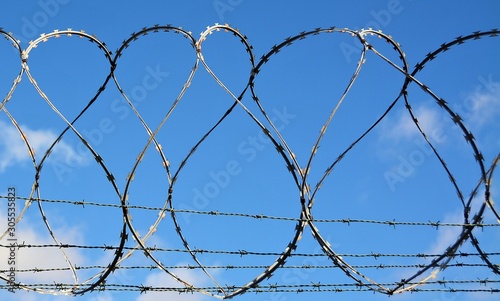 a circular barbed fence against the background of the blue sky
