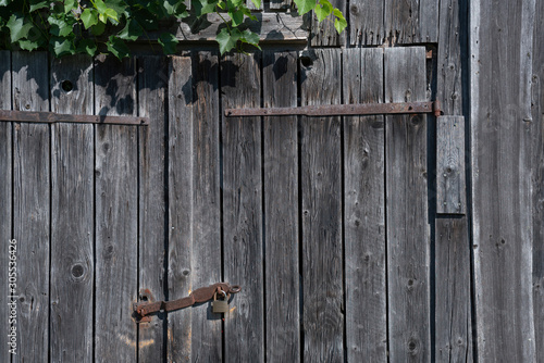 Detail of a rusty padlock at weathered wooden planks