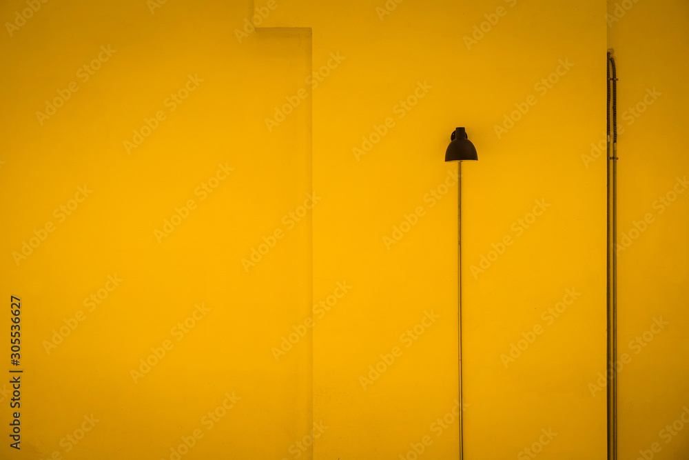 Black lamp against yellow wall. Minimal Aesthetic. Black lamp against yellow wall. Minimal Aesthetic.