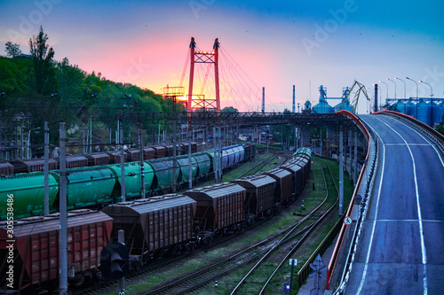 railroad transportation, freight cars in industrial seaport at sunset