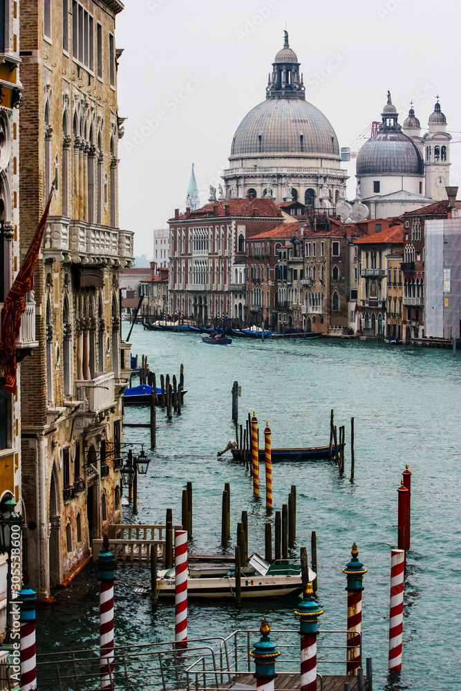 view of the Grand Canal during a cloudy day with the Cathedral of Santa Maria in the background, venice, italy