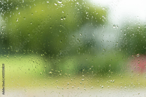 View through a window with raindrops, unsharp colours in the background