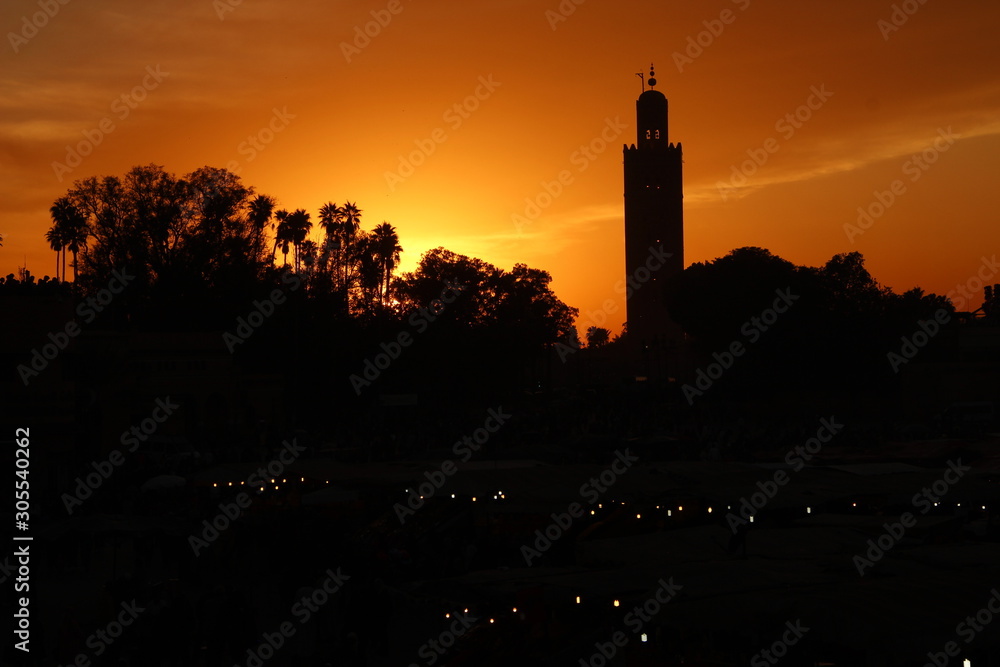Orange sunset in the tower of the Marrakech square from a terrace. Morocco