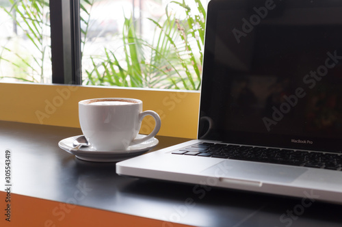 cup of coffee and laptop on table
