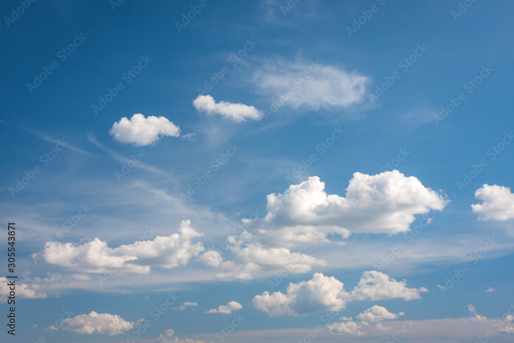 Fototapeta premium Cumulus clouds slowly moving in the blue summer sky