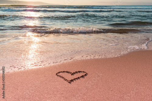 Valentine s day on the beach. Heart on the beach on the sand. Travel and holidays concept. Space for text.