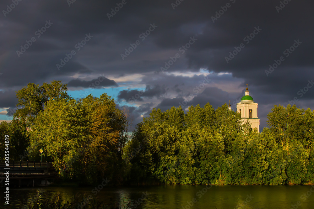 Summer landscape with a Christian church by the river