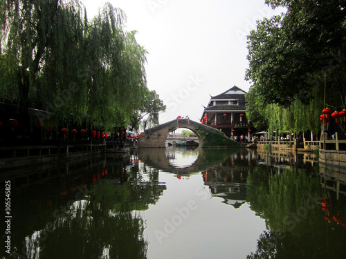 Ancient bridge with water reflection and lanterns in Zhouzhuang, China