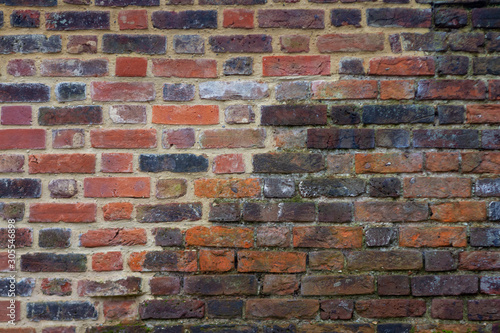 Historic old brick wall from the 12th century partially restored