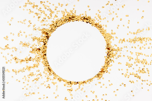 Gold holiday composition. Frame made of golden decorations confetti on white background. Christmas, New Year, Wedding, Birthday. Flat lay, top view, copy space.