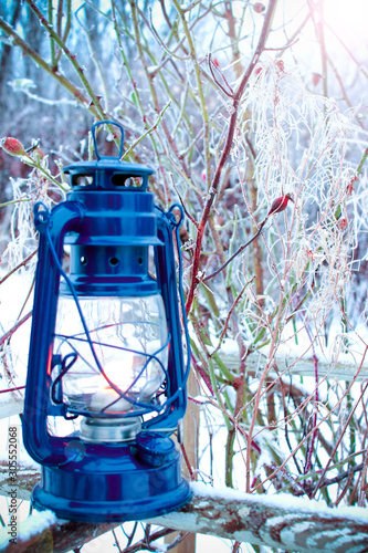 Winter, Christmas. An old lamp stands in the forest against a background of snowy branches
