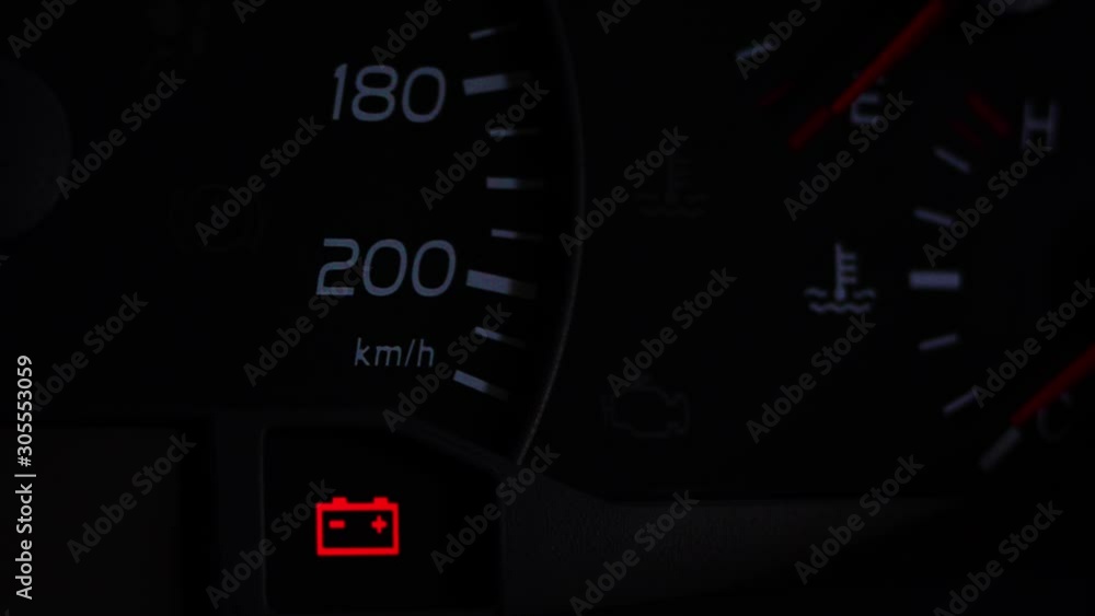 Close up footage of a car's dashboard, with the battery warning light