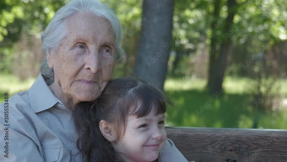 With grandma in the park. Happy little girl with her grandmother in the park on the bench. With grandma in the park. Happy little girl with her grandmother in the park on the bench.