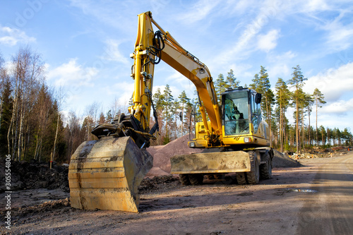 Yellow excavator building a road deep in the forest. Rusko, Finland.