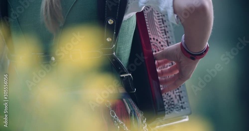 Close up slow motion shot, musician in traditional music costume playing  accordion, 4K.