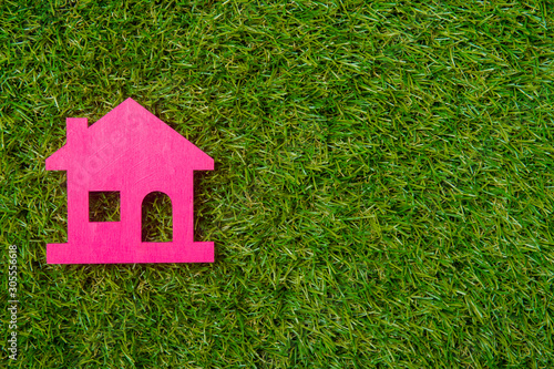 Pink house on green grass background. Eco friendly.