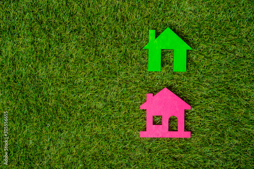Green and pink house on green grass background. Eco friendly.