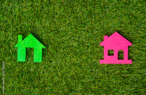 Green and pink house on green grass background. Eco friendly.
