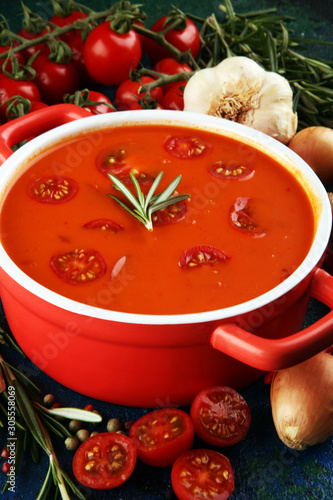 Tomato and fresh rosemary soup with garlic, cracked papper corns, served with cream. Homade tomato soup for dinner
