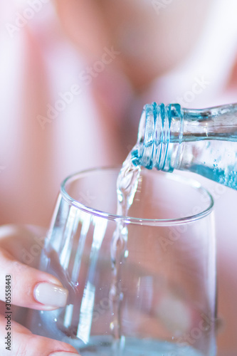 Woman's Hand Pouring Fresh pure Water From bottle.