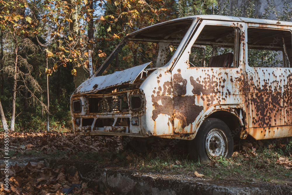 Old abandoned rusty car in a park. Old abandoned rusty car in a park.