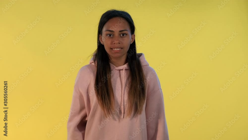 Pretty multiracial woman cheering for the team. Yellow background. Pretty multiracial woman cheering for the team. Yellow background.