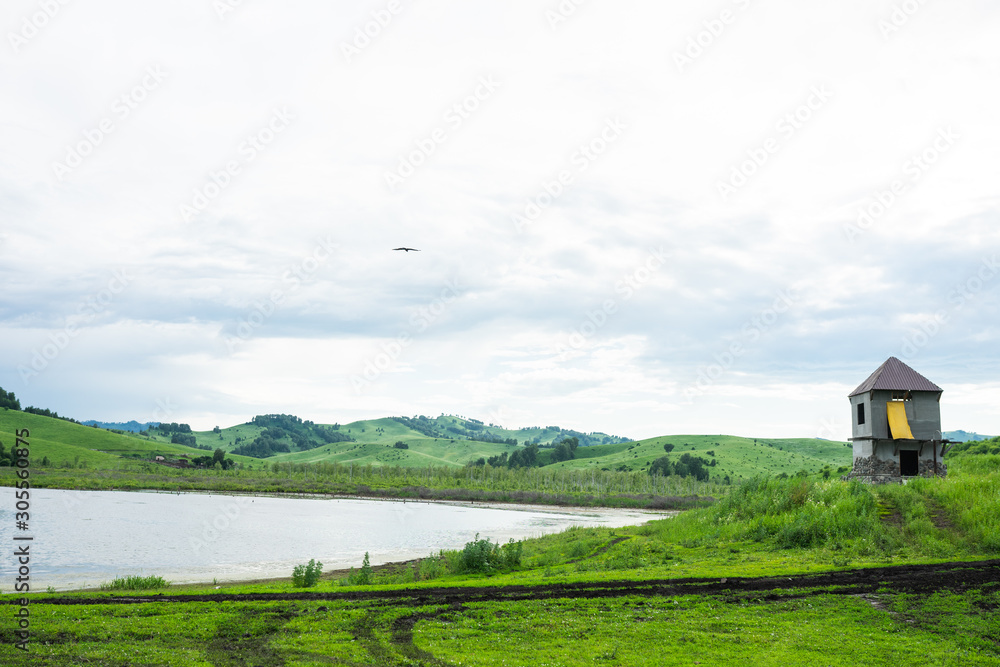 Russian green hills and meadows in Altai. Aya Lake for tourists. The sun and sunset of the day. Summer and grass. Nature travel