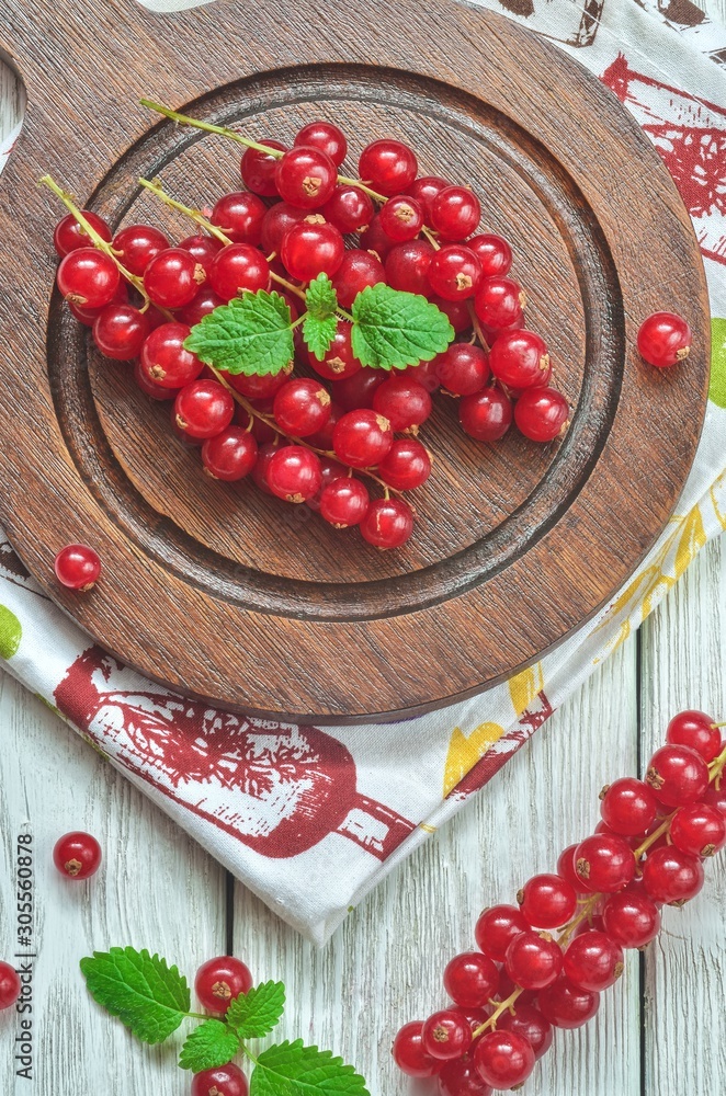 Red fruit in the kitchen. Red currant on a white wooden table. Red fruit in the kitchen. Red currant on a white wooden table.